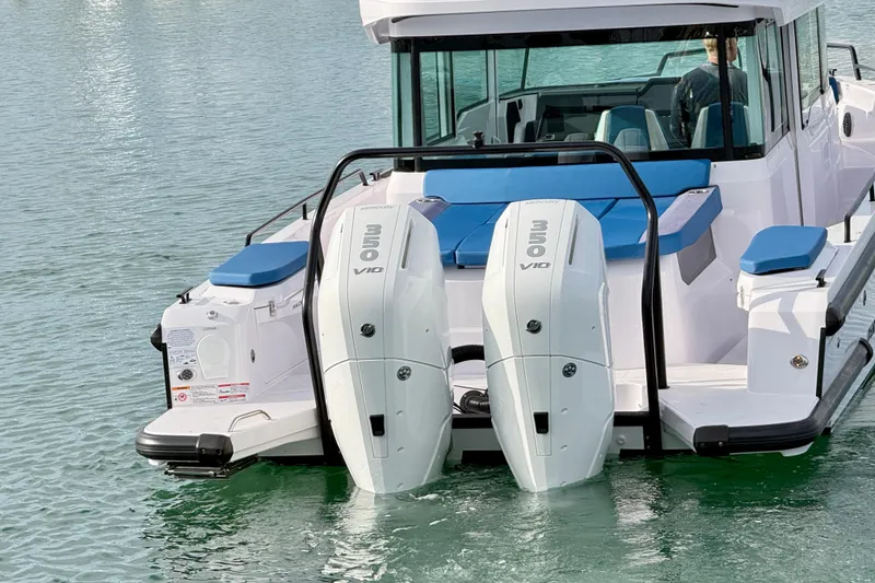 Slide: The Image of 2025 Axopar 37 XC Cross Cabin boat docked in a marina with twin engines. - 4