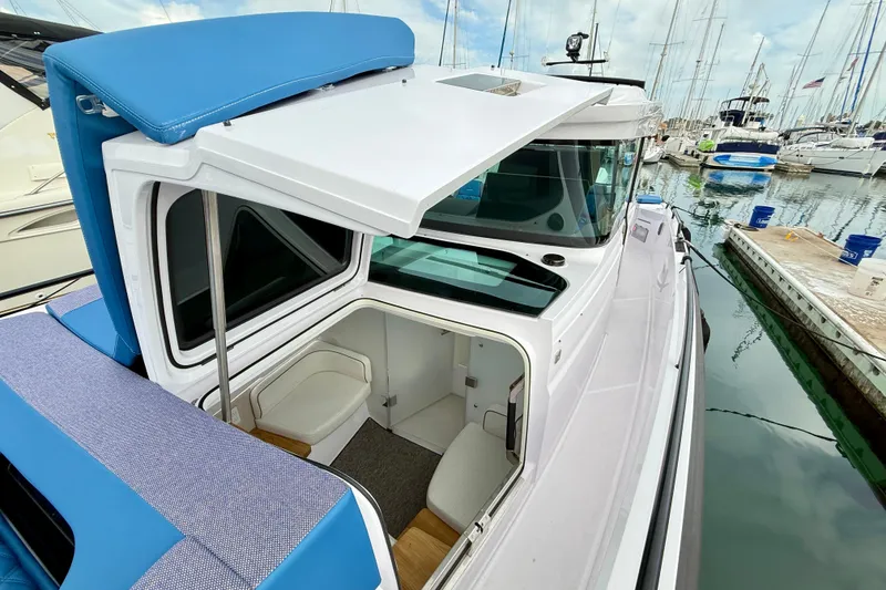 Slide: The Image of 2025 Axopar 37 XC Cross Cabin boat docked, showcasing open cabin and sleek design. - 42