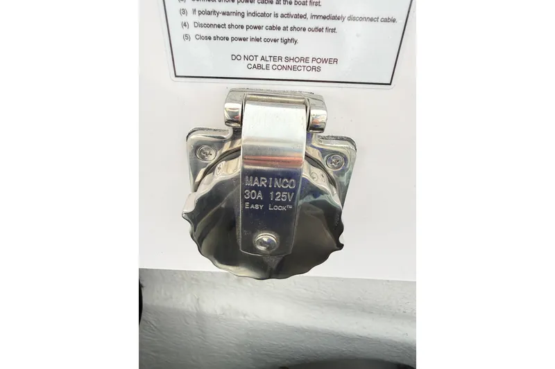 Slide: The Image of Shore power connector on 2025 Axopar 37 XC Cross Cabin, 30A 125V, with safety instructions. - 48