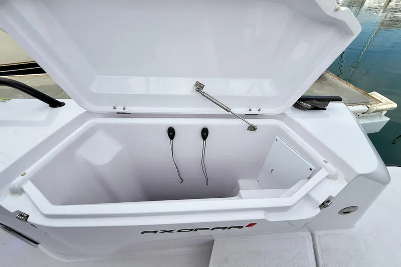 Slide: The Image of Open storage compartment on 2025 Axopar 37 XC Cross Cabin boat, dockside view. - 54