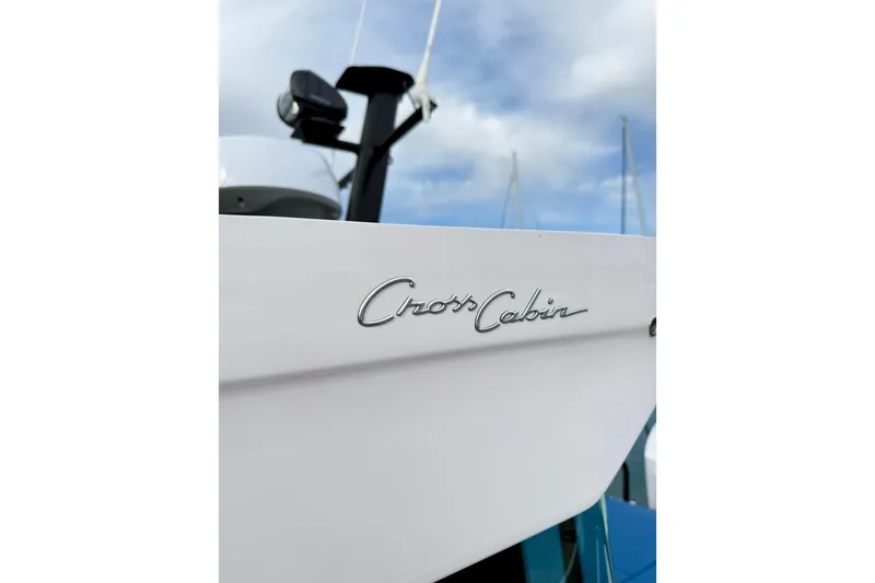 Slide: The Image of 2025 Axopar 37 XC Cross Cabin boat with sleek design and "Cross Cabin" logo. - 58