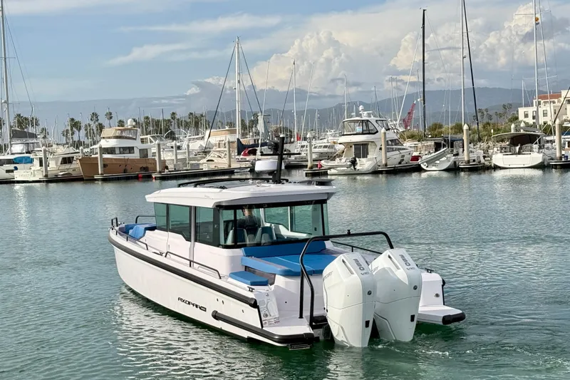 Slide: The Image of 2025 Axopar 37 XC Cross Cabin boat in marina, clear sky, calm water. - 6