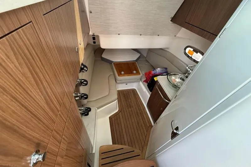 Slide: The Image of 2024 Boston Whaler 380 Outrage cabin interior with wood accents and seating area. - 14