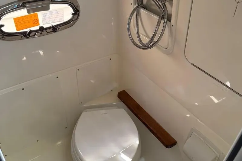 Slide: The Image of 2024 Boston Whaler 380 Outrage boat bathroom with toilet and showerhead. - 15