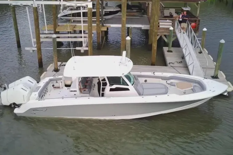 Slide: The Image of 2024 Boston Whaler 380 Outrage docked at marina, side view. - 3
