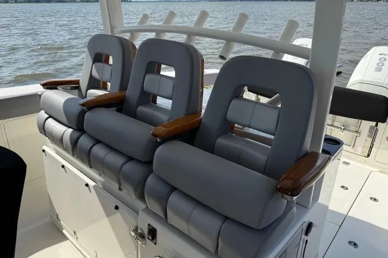 Slide: The Image of 2024 Boston Whaler 380 Outrage boat seats with wooden armrests on open water. - 9