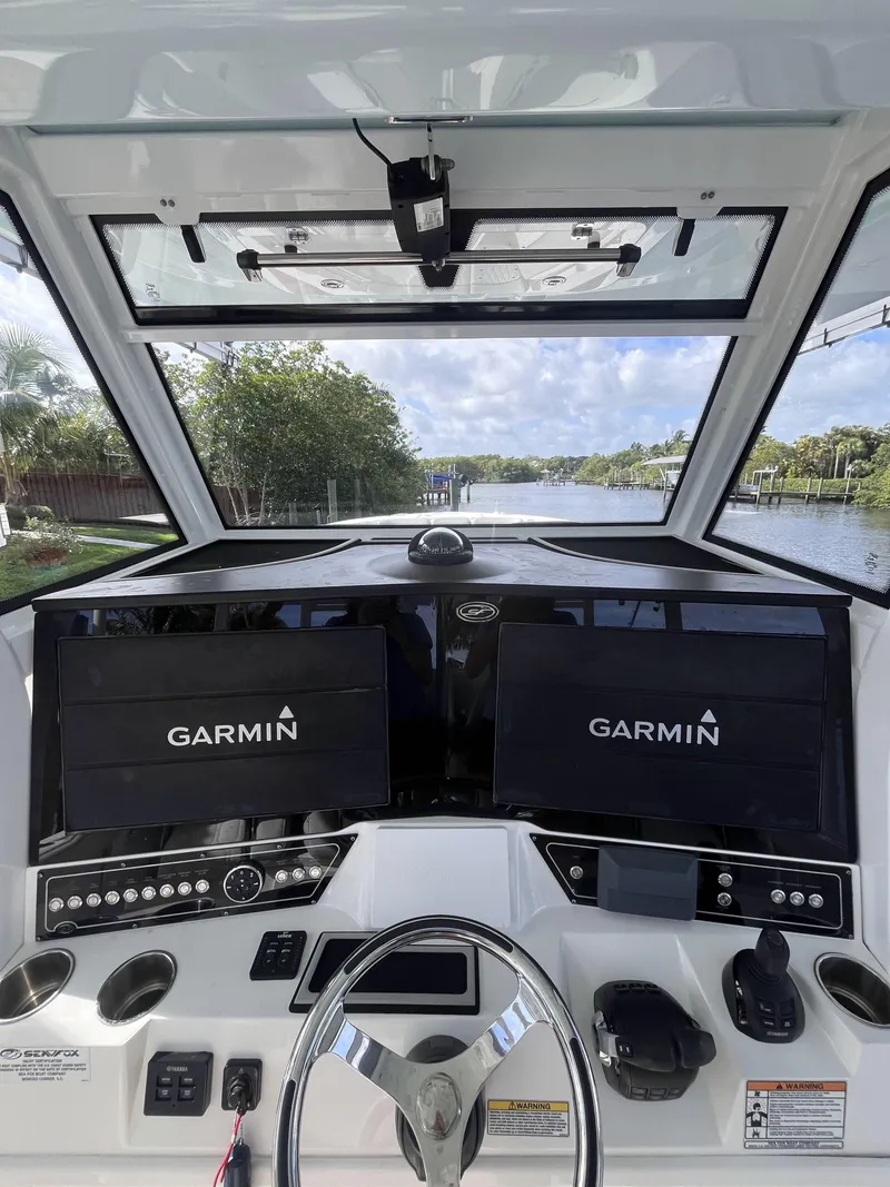 Slide: The Image of 2021 Sea Fox 368 Commander helm with dual Garmin displays on a scenic waterway. - 15