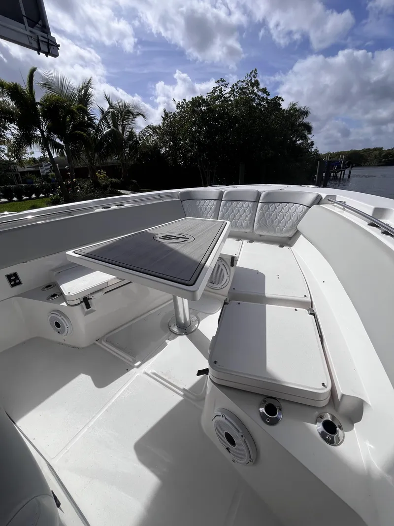 Slide: The Image of 2021 Sea Fox 368 Commander boat interior with seating and table, under a partly cloudy sky. - 23