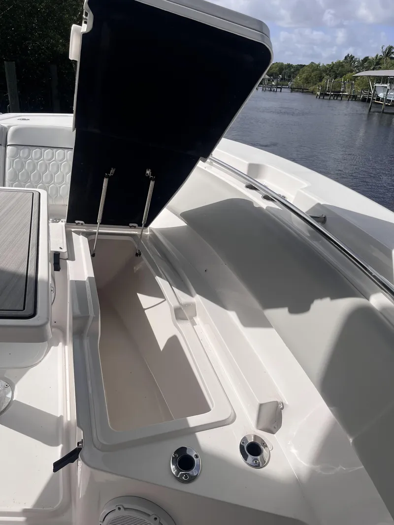Slide: The Image of 2021 Sea Fox 368 Commander boat with open storage compartment, docked by a scenic waterway. - 24