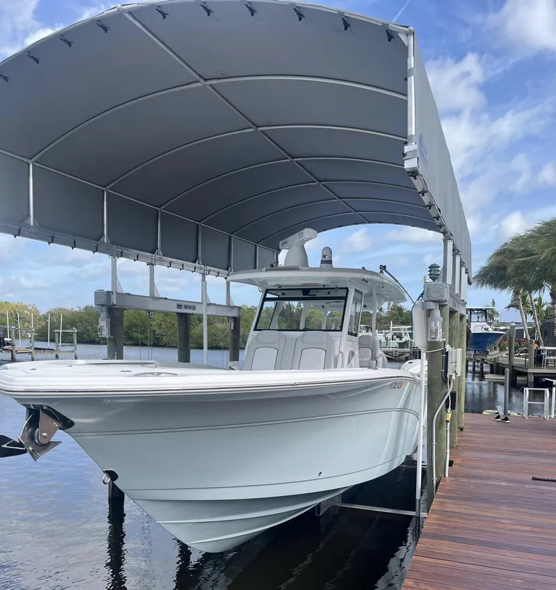 Slide: The Image of 2021 Sea Fox 368 Commander boat docked under canopy on a sunny day. - 27