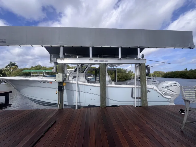 Slide: The Image of 2021 Sea Fox 368 Commander boat docked under a covered lift on a wooden pier. - 4