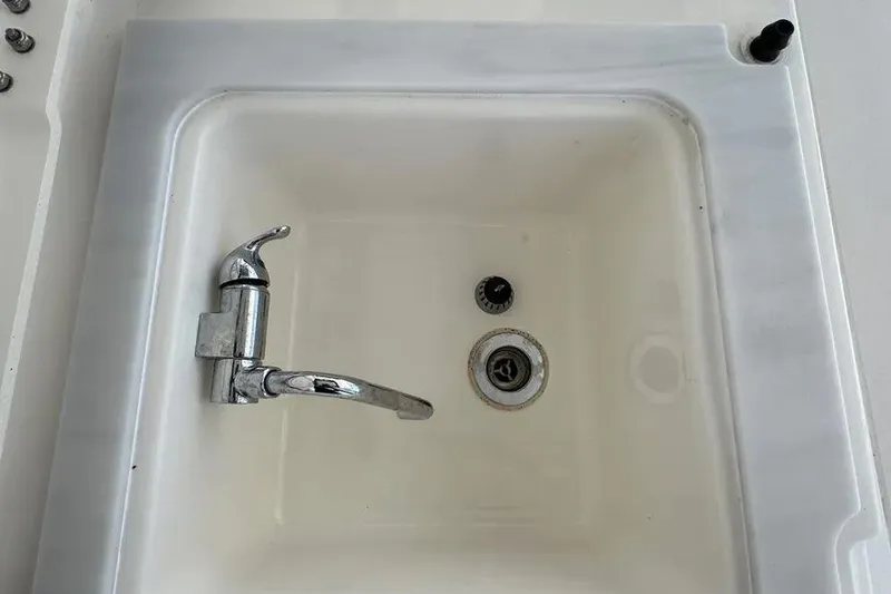 Slide: The Image of 2024 Pursuit S 358 Sport boat sink with chrome faucet and drain. - 13