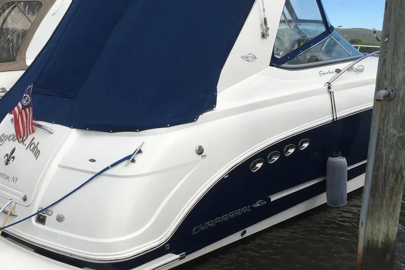 Slide: The Image of 2009 Chaparral Signature 350 boat docked, featuring blue and white design with American flag. - 4