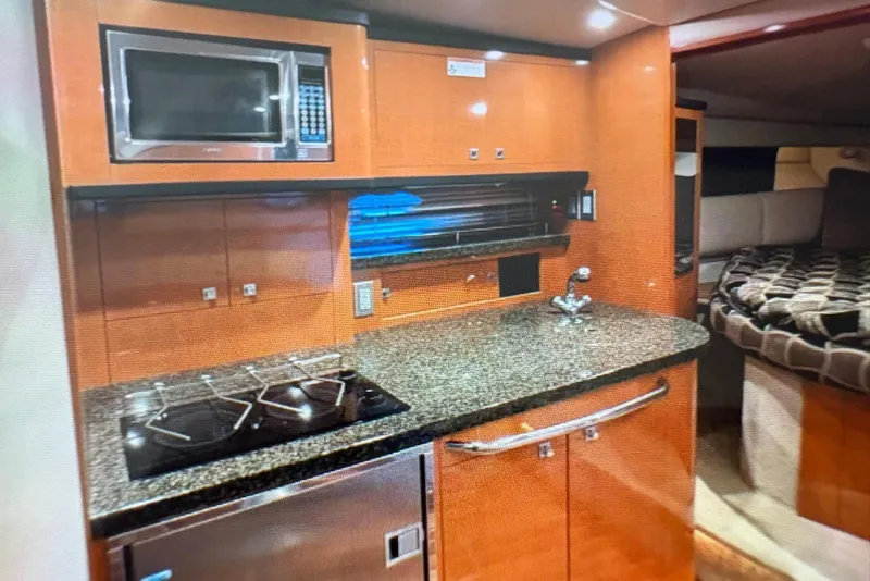 Slide: The Image of 2009 Chaparral Signature 350 yacht interior kitchen with microwave, stove, and granite countertop. - 5