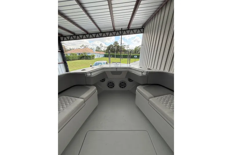Slide: The Image of 2025 Contender 44 ST boat interior with cushioned seating in a covered storage area. - 11