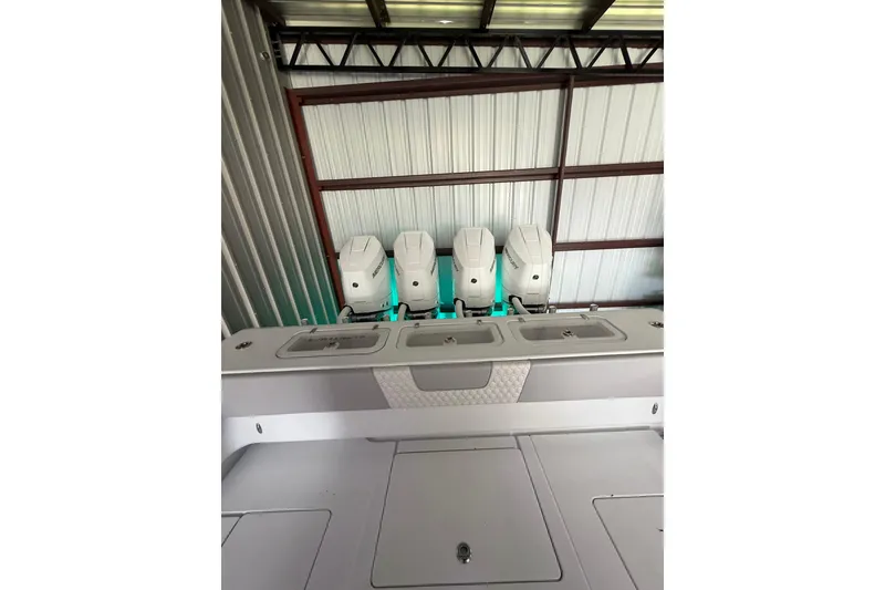 Slide: The Image of 2025 Contender 44 ST boat with four powerful outboard engines in a metal storage facility. - 12