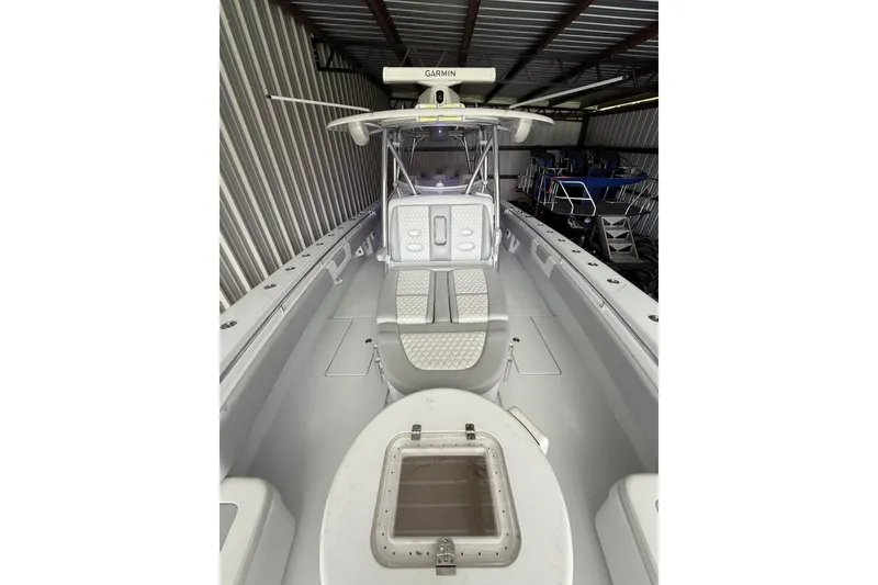 Slide: The Image of 2025 Contender 44 ST boat interior with white seating and Garmin equipment in storage. - 5