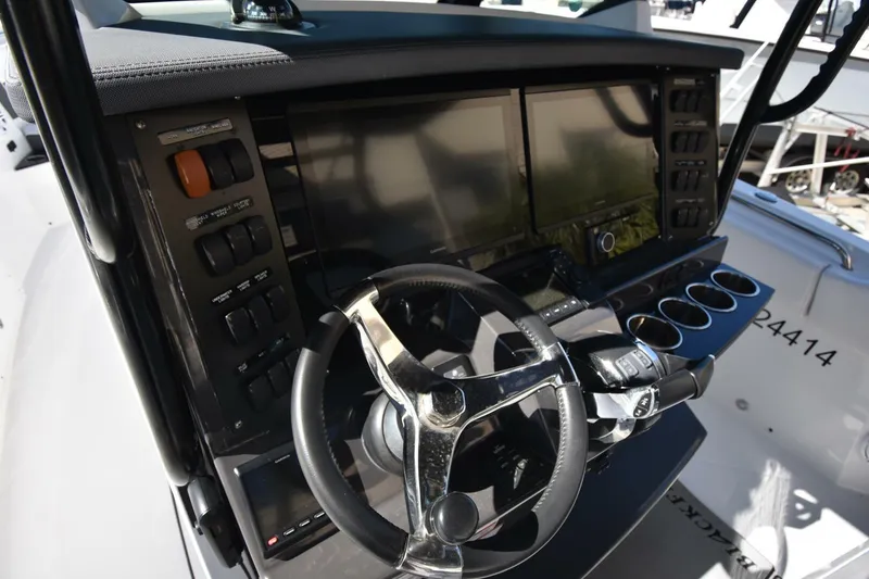 Slide: The Image of 2021 Blackfin 332 CC boat dashboard with steering wheel and control panels. - 16
