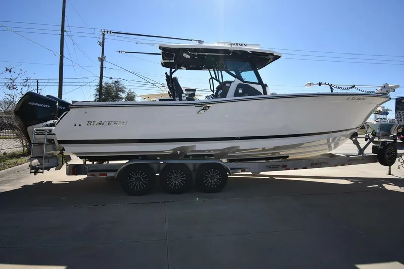 Slide: The Image of 2021 Blackfin 332 CC boat on trailer, side view, outdoors. - 2