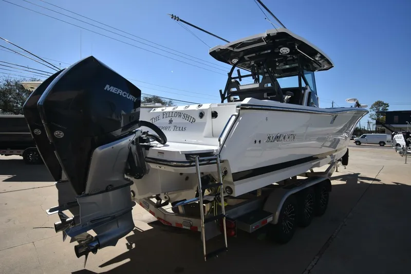 Slide: The Image of 2021 Blackfin 332 CC boat on trailer with Mercury outboard engine, parked outdoors. - 28