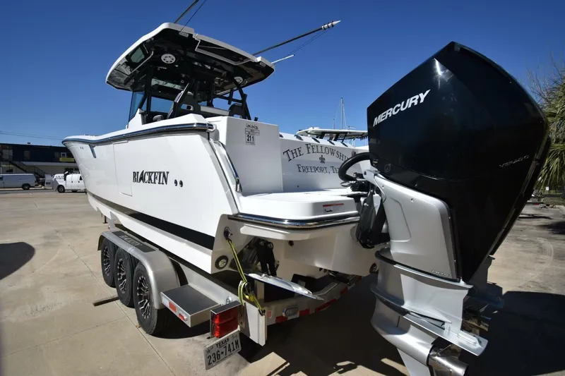 Slide: The Image of 2021 Blackfin 332 CC boat with Mercury engine on trailer, parked outdoors. - 29