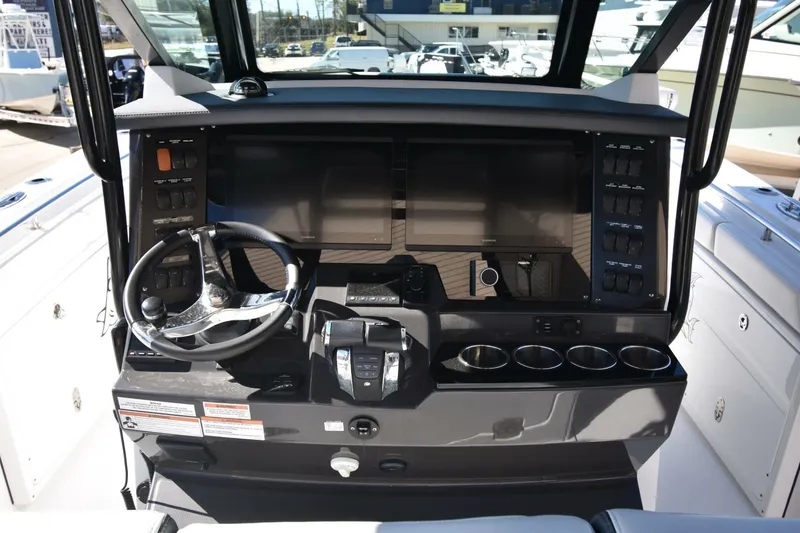 Slide: The Image of 2021 Blackfin 332 CC boat dashboard with steering wheel and control panel. - 3