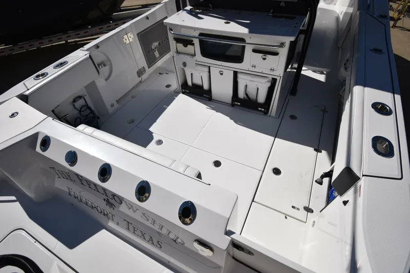 Slide: The Image of 2021 Blackfin 332 CC boat interior with fishing rod holders and storage compartments. - 6
