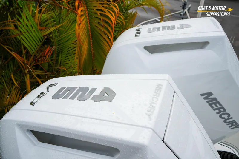 Slide: The Image of 2026 Blackfin 332 CC boat with Mercury engines, wet from rain, near tropical plants. - 17