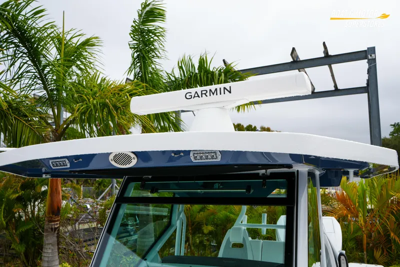 Slide: The Image of 2026 Blackfin 332 CC boat with Garmin radar, surrounded by tropical palm trees. - 32