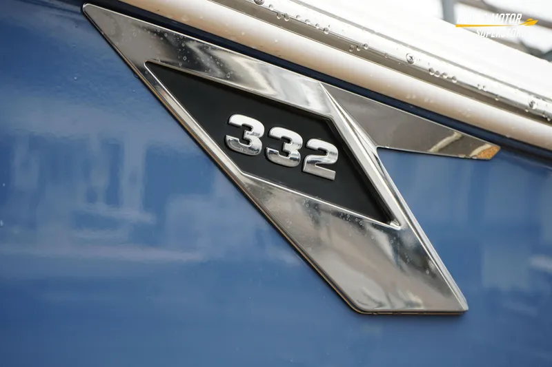 Slide: The Image of 2026 Blackfin 332 CC boat emblem on blue hull, showcasing sleek design. - 5