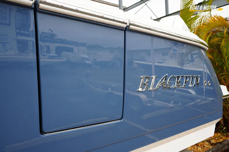 Slide: The Image of 2026 Blackfin 332 CC boat with sleek blue exterior and chrome logo. - 6
