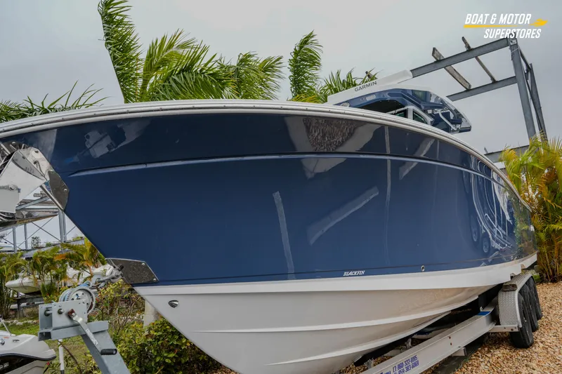 Slide: The Image of 2026 Blackfin 332 CC boat on trailer, surrounded by tropical plants. - 9