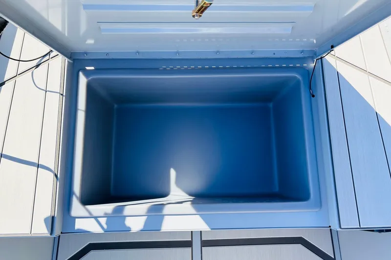 Slide: The Image of 2026 Tracker Bass Tracker Classic CC livewell, open lid, showing spacious interior. - 14