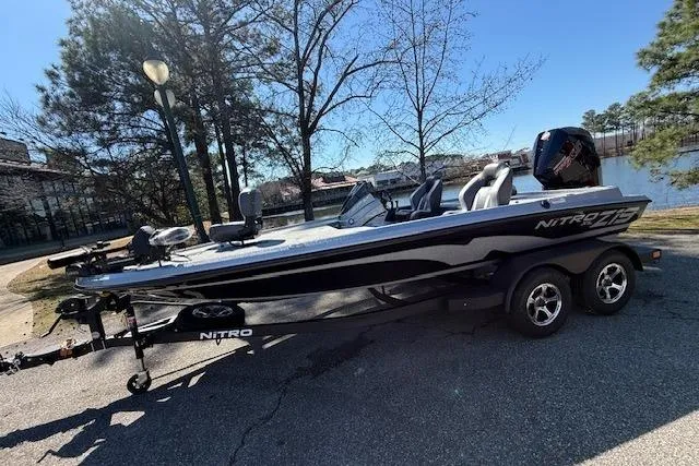 The Image of 2026 Nitro Z19 XL Pro boat parked near a scenic lake with trees. - 0