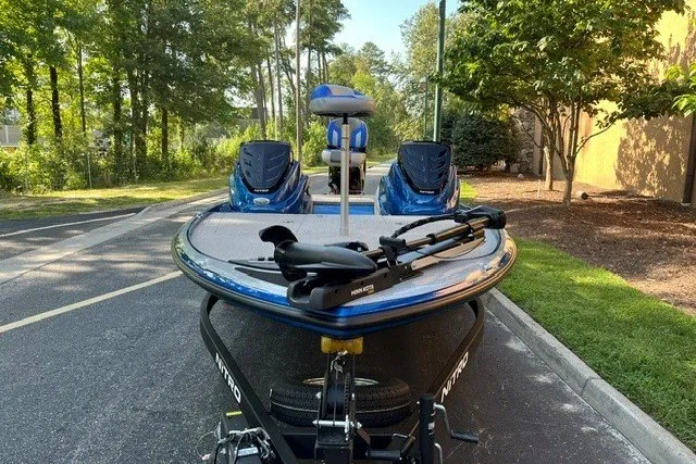 Slide: The Image of 2026 Nitro Z17 boat with dual motors parked on a tree-lined street. - 2