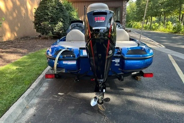 Slide: The Image of Blue Nitro Z17 boat with Mercury 115 engine, parked on a driveway. - 3