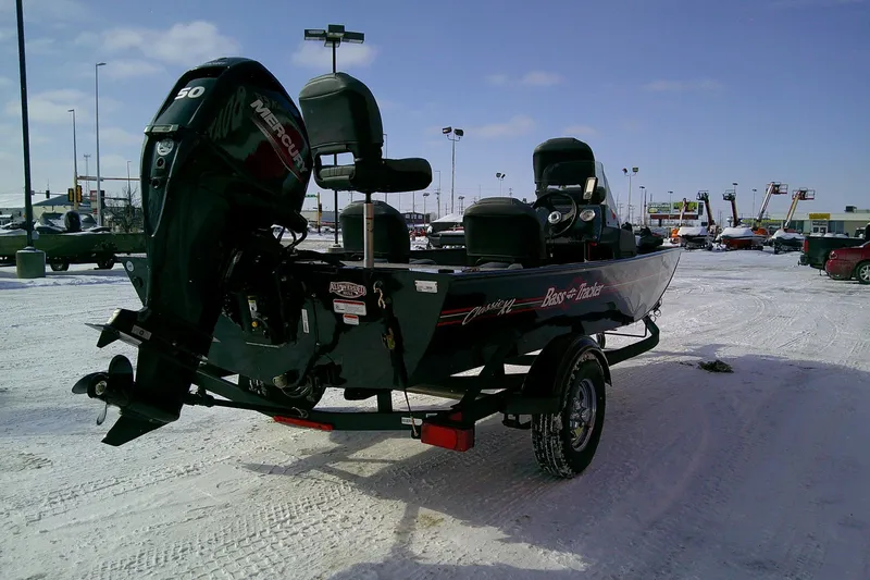 Slide: The Image of 2026 Tracker Bass Tracker Classic XL boat on snowy lot with Mercury engine. - 65