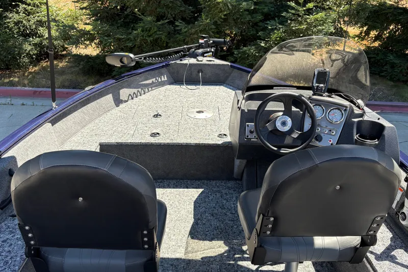 Slide: The Image of Interior view of 2026 Tracker Pro Guide V-16 SC boat with steering console and seating. - 17