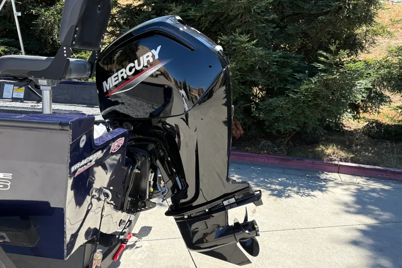 Slide: The Image of 2026 Tracker Pro Guide V-16 SC boat with Mercury outboard motor, parked outdoors. - 10