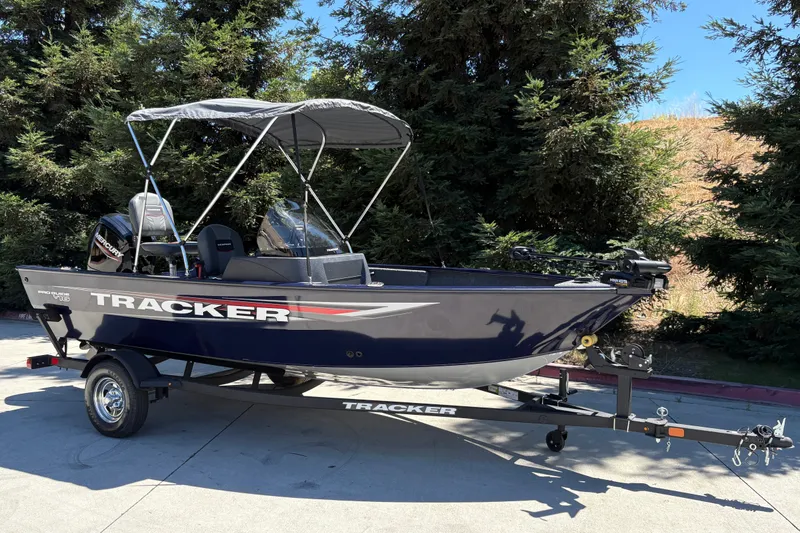 Slide: The Image of 2026 Tracker Pro Guide V-16 SC boat on trailer, parked outdoors. - 2