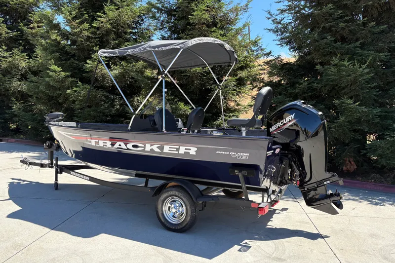 Slide: The Image of 2026 Tracker Pro Guide V-16 SC boat with Mercury engine, parked outdoors. - 4