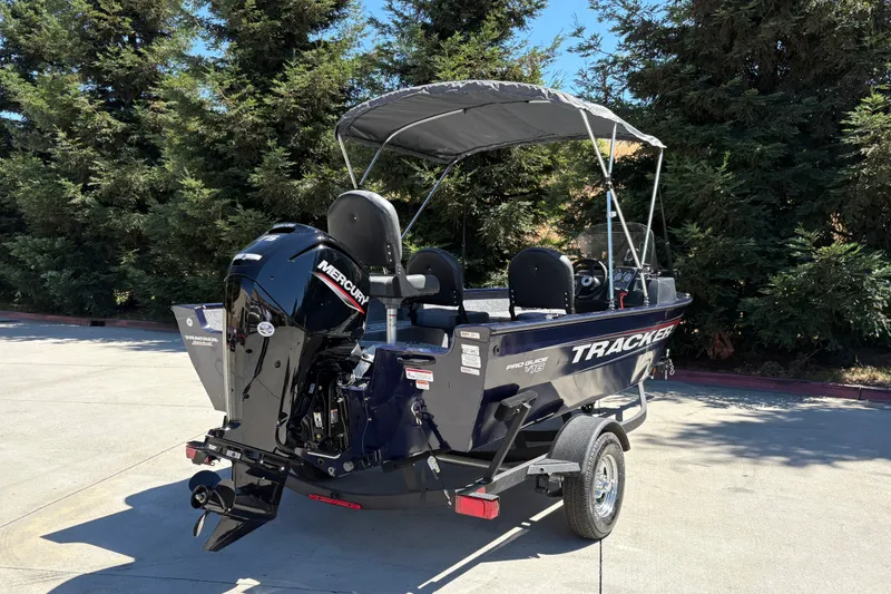 Slide: The Image of 2026 Tracker Pro Guide V-16 SC boat with Mercury engine, parked outdoors. - 13