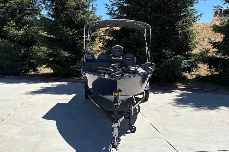 Slide: The Image of 2026 Tracker Pro Guide V-16 SC boat on trailer, parked outdoors near trees. - 8