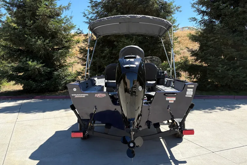 Slide: The Image of 2026 Tracker Pro Guide V-16 SC boat with Mercury 75 engine, parked outdoors. - 11