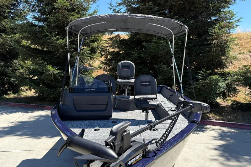 Slide: The Image of 2026 Tracker Pro Guide V-16 SC boat with canopy, parked outdoors. - 14