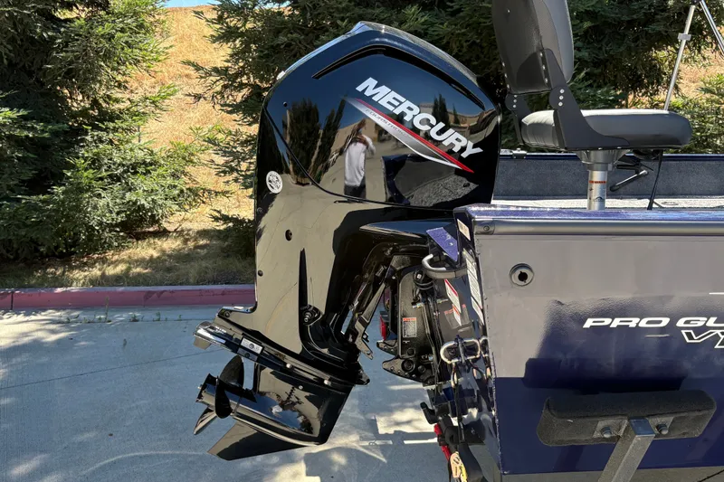 Slide: The Image of 2026 Tracker Pro Guide V-16 SC boat with Mercury outboard motor, parked outdoors. - 9