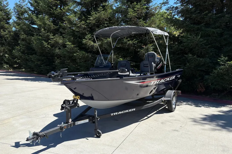 Slide: The Image of 2026 Tracker Pro Guide V-16 SC boat on trailer, parked outdoors. - 6