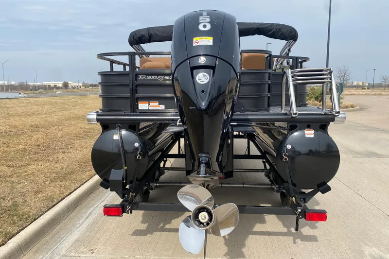 Slide: The Image of 2026 Ranger 220F boat with powerful outboard motor, parked on a concrete surface. - 58