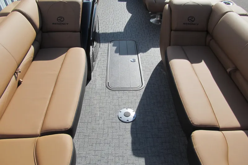Slide: The Image of 2026 Regency 230 DL boat interior with tan seating and carpeted flooring. - 10