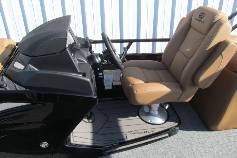 Slide: The Image of 2026 Regency 230 DL boat helm with tan captain's chair and sleek black console. - 15